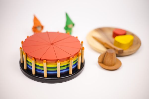 v59 631 202602031611 00.jpg Colourful wooden toy cake and shapes on table.