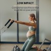 folding pilates reformer machine – home workout bed for full body fitness training Pregnant woman doing low impact exercise with straps.