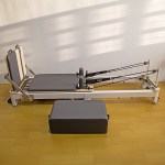 Pilates reformer machine on wooden floor.