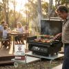 Man barbecuing with family in backyard