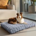 plush pet bed with non slip base and removable cover Dog resting on fluffy grey bed indoors.
