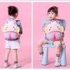 Toddler with cute cartoon backpack on pink background