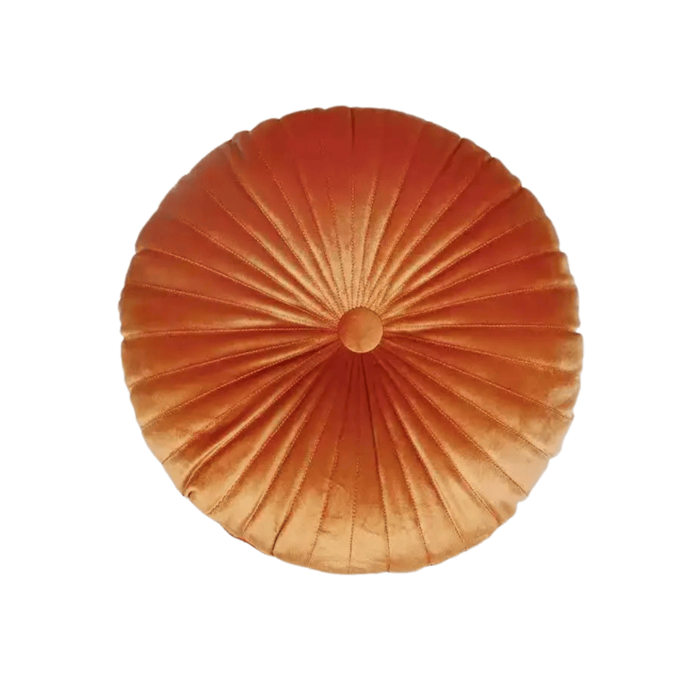 Round pleated orange velvet cushion on white background