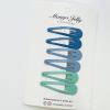 Blue and green snap hair clips on card