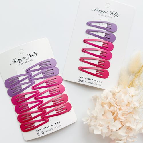 Pink and purple snap hair clips on display cards