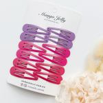 Pink and purple snap hair clips on display card