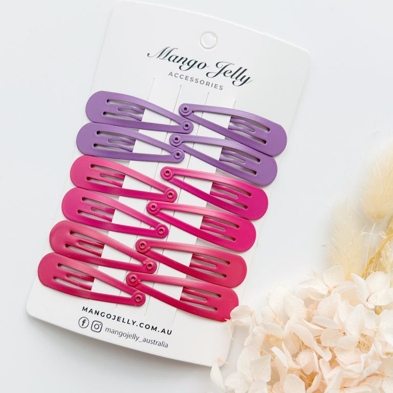 Pink and purple snap hair clips on display card