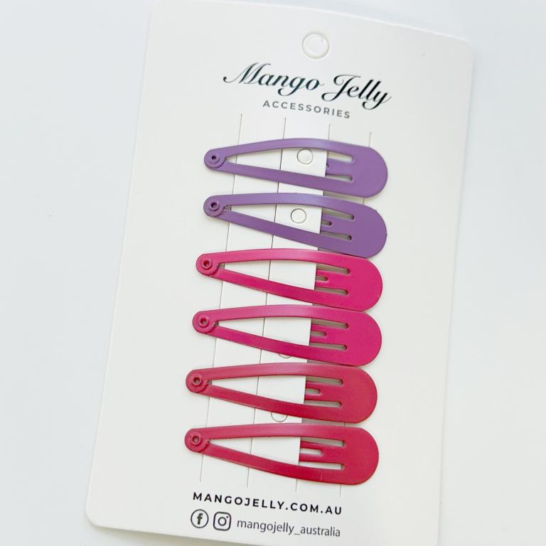Purple and pink snap hair clips on card