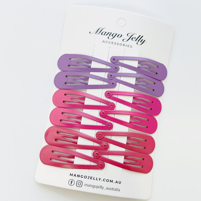 Pink and purple snap hair clips on card