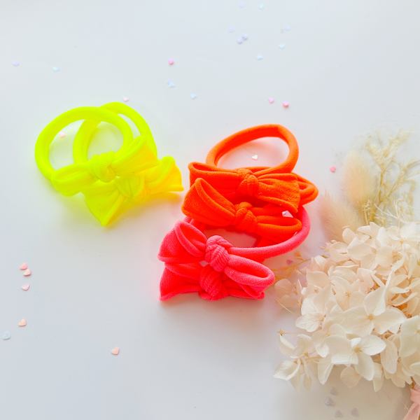 v659 ht metalfree bow 1p npink 202511101925 00.jpg Neon bow hair ties on white background