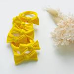 Bright yellow bow headbands on white background