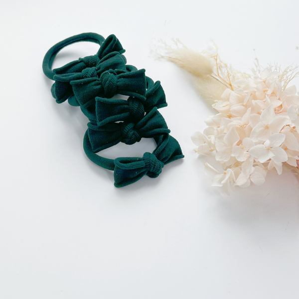 handmade simple bows school colours maroon 1 pairs Green bow hair ties beside dried flowers