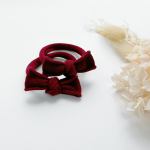 Red bow headbands on white background with dried flowers