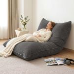 Woman relaxing on grey floor lounge chair indoors