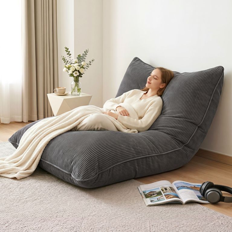 Woman relaxing on grey floor lounge chair indoors