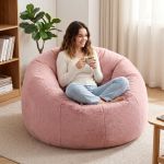 Woman relaxing on pink bean bag with coffee
