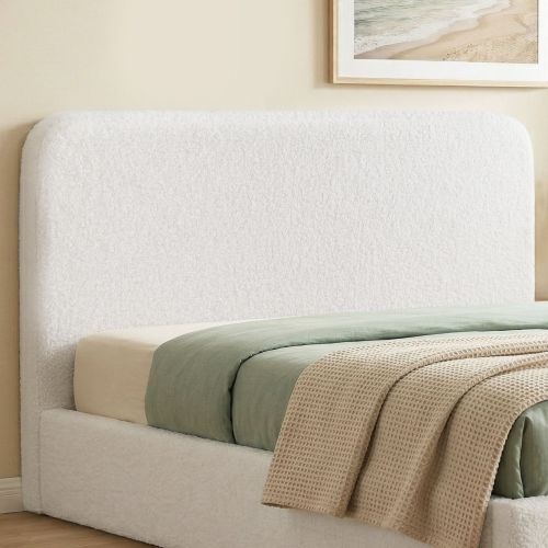 Upholstered bed with green bedding and beach artwork