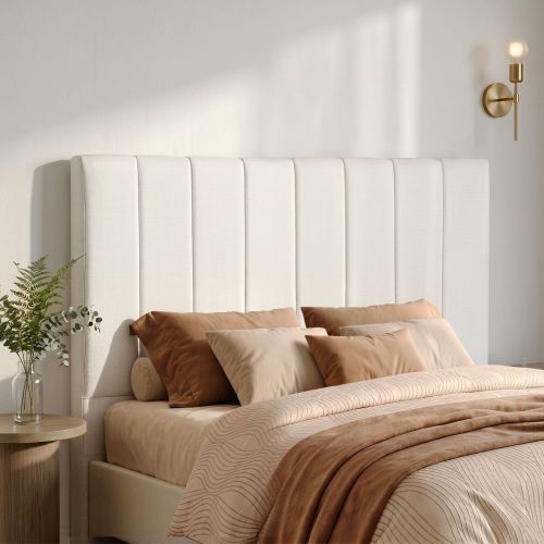 Modern bedroom with upholstered headboard and brass sconce