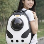 image 1 Woman wearing penguin pet backpack with cat