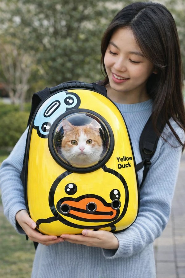 image 1 Woman holding yellow duck pet backpack with cat
