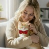 image 2 Woman cuddling ginger kitten wearing red bow tie