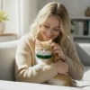 Woman cuddling ginger kitten on sofa indoors