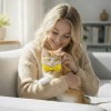 Woman cuddling ginger kitten with yellow bow