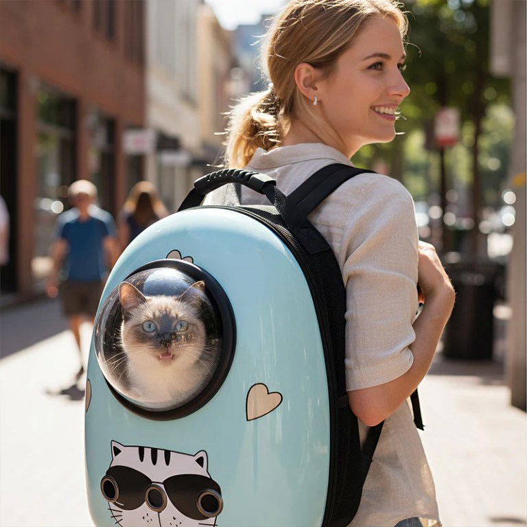 image 2 Woman carrying cat in bubble backpack outdoors