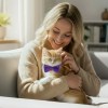 Woman cuddling kitten wearing purple bow tie