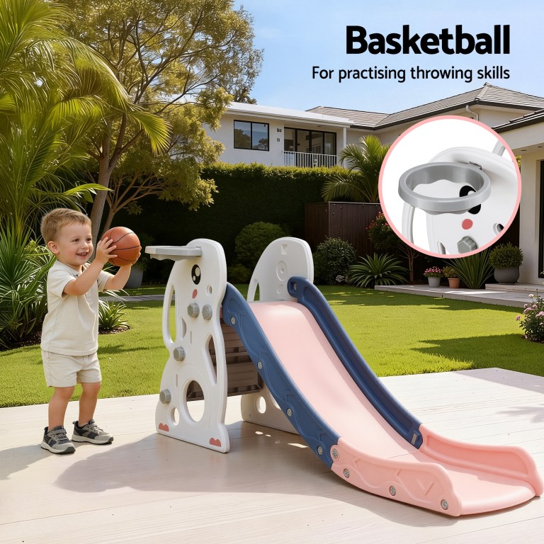 Toddler playing basketball beside backyard slide set