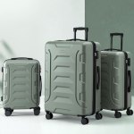 Three sage green hard-shell suitcases with wheels
