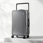 Grey hard-shell suitcase with telescopic handle and wheels