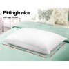 White pillow on mint bedspread with dimensions