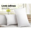 Two white pillows on bed by window