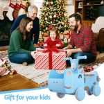 Family opening Christmas present by decorated tree
