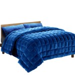 Blue quilted bedspread on wooden bed frame