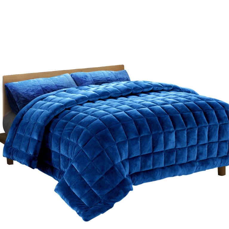 Blue quilted bedspread on wooden bed frame