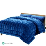 Deep blue quilted bedspread on wooden bed