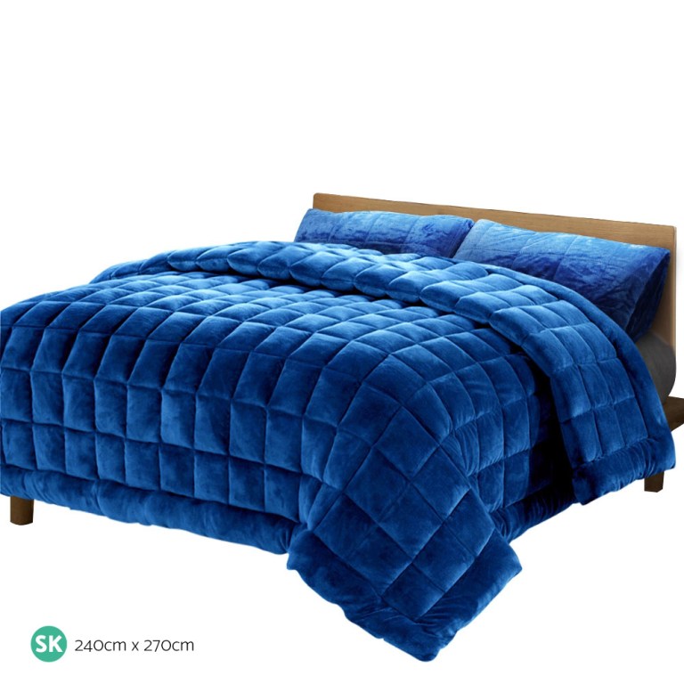 Deep blue quilted bedspread on wooden bed