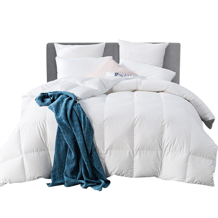 White quilted bed with teal throw blanket