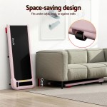Foldable treadmill stored upright beside sofa