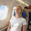 Woman resting with neck pillow on airplane