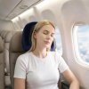 Woman sleeping on plane with neck pillow