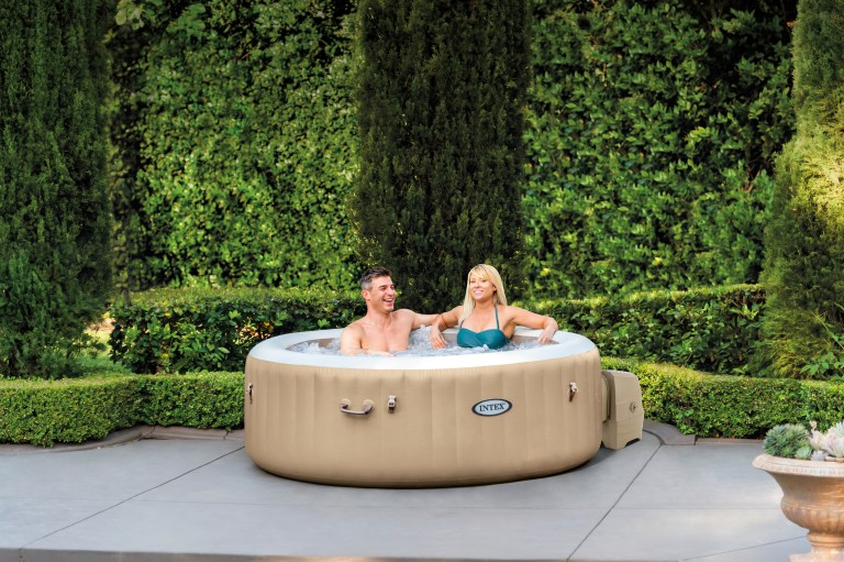 Couple relaxing in inflatable backyard spa
