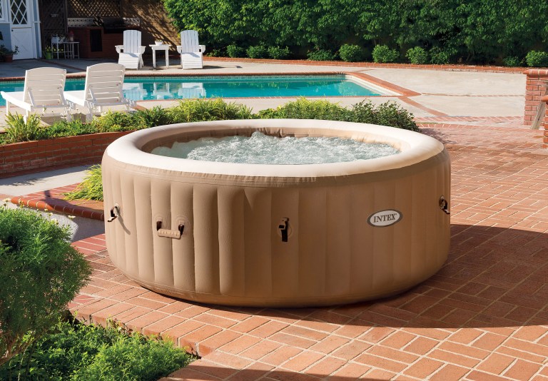 Inflatable spa on brick patio near pool