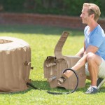 Man inflating outdoor spa with electric pump