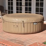 Inflatable outdoor spa with cover on brick patio