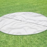 Round grey mat on green artificial grass