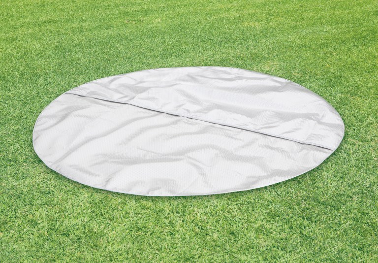 Round grey mat on green artificial grass