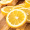 lemon essential oil Fresh lemon slices on wooden cutting board